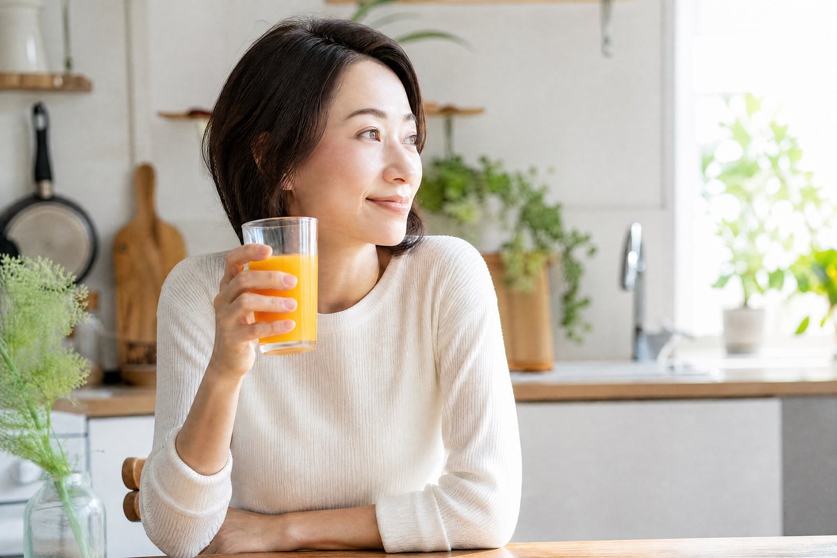 キッチンでサジードリンクを飲む女性